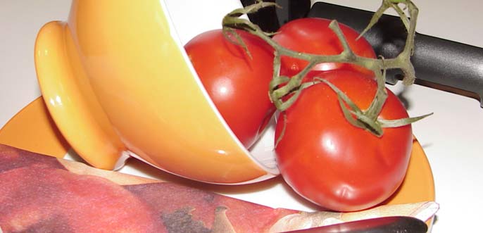 Stillleben aus Tomaten und Geschirr nebst Messer.