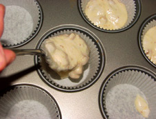 Den Teig portionsweise in die gutgefetteten Muffinformen einfüllen.
