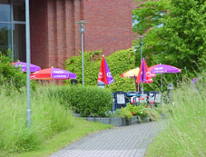 Außenansicht: Bestuhlung mit Schirmen vor der Mensa der Fachhochschule!